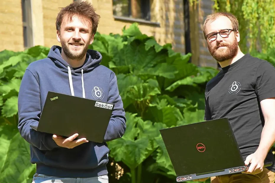 Photo de Léo Richer et Christophe Hauquiert debout avec leur ordinateur entre les mains.