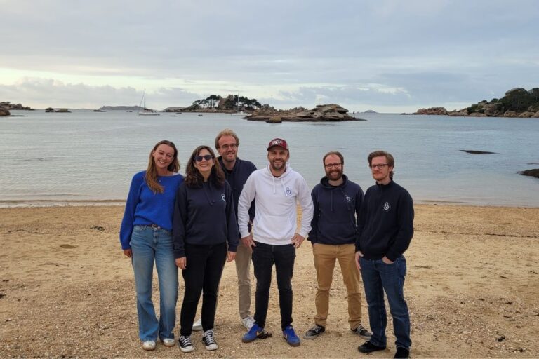 Photo de l’équipe Sekost en bord de mer, sur une plage. De gauche à droite : Inès, Lisa, Samuel, Léo, Christophe et Damien, tous souriants.