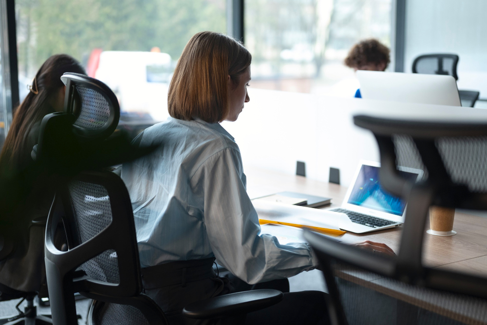 Une employée assise devant son ordinateur regarde des indicateurs