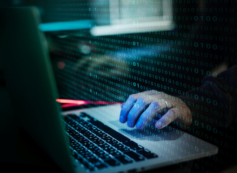 Illustration d'un piratage informatique avec un homme devant des lignes de codes, pour décider que faire en cas d’attaque