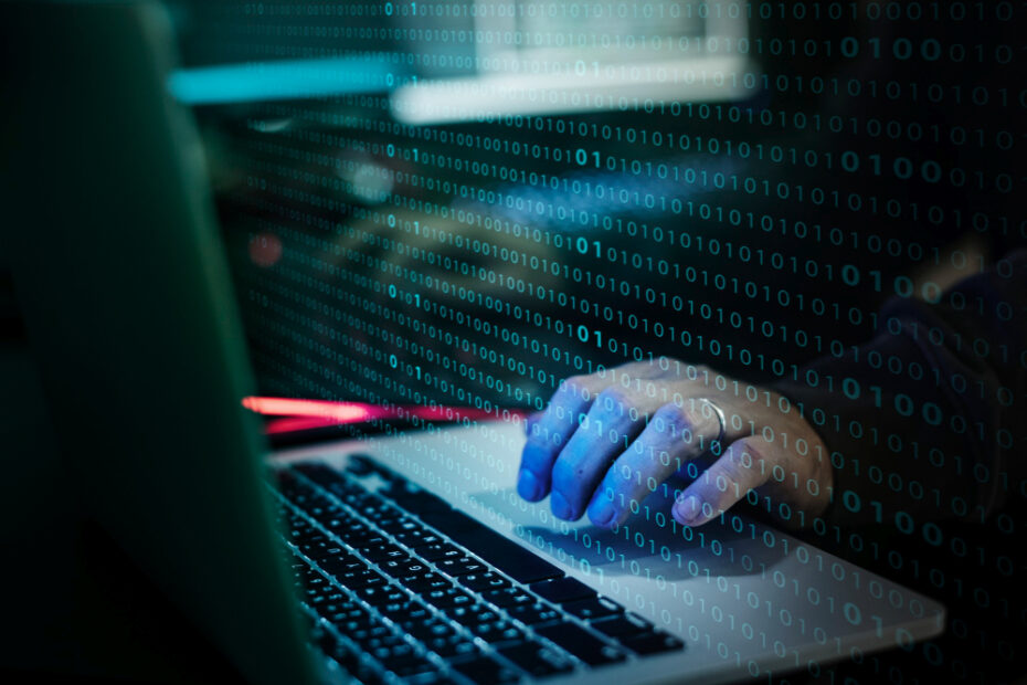 Illustration d'un piratage informatique avec un homme devant des lignes de codes, pour décider que faire en cas d’attaque