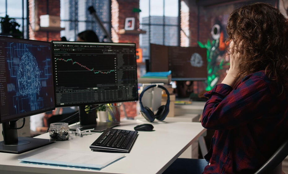 Un femme devant son ordinateur voit un de ses deux écrans porter un logo d'une cyberattaque