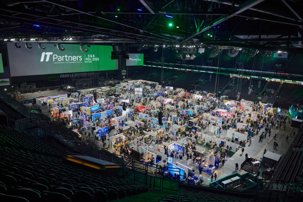 Une image du salon IT Partners, vue de haut sur les stands et l'écran géant