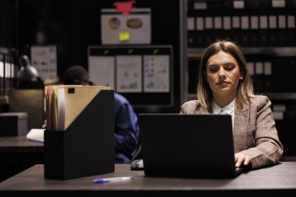Une femme consulte son ordinateur pour stopper la cyberattaque qui touche sa collectivité.